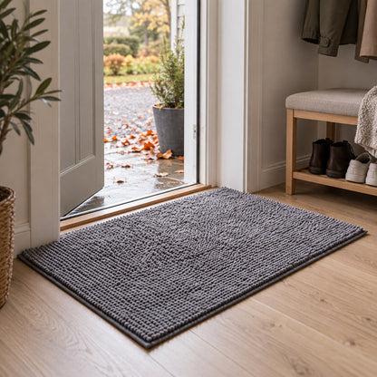 Tassro Mattan i mörkgrå innanför ytterdörren i en ljus skandinavisk hall